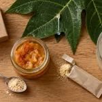 Papaye fermentée en pot, cuillère de poudre et verre d’eau